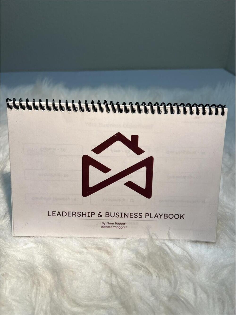 spiral-bound "Leadership & Business Playbook" created by Sam Taggart